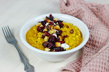 pumpkin risotto with cheese dried cranberry nuts on a light background