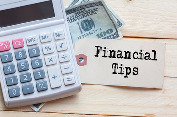 Financial Tips Words on tag with dollar note and calculator on wood backgroud,Finance Concept