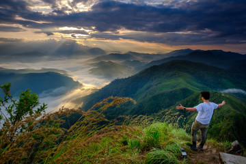 Fototapeta premium A man standing on top of the mountain view in the morning in Lerkwador, Tak province, Thailand
