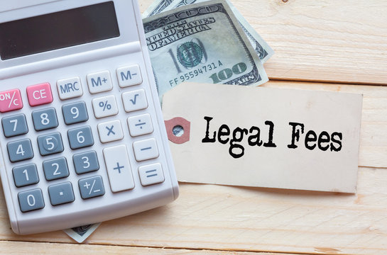 Legal Fees Words on tag with dollar note and calculator on wood backgroud,Finance Concept