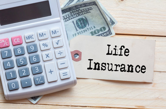 Life Insurance Words on tag with dollar note and calculator on wood backgroud,Finance Concept