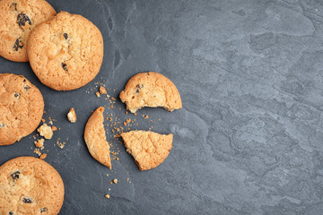 Delicious cookies with raisins on black table, flat lay. Space for text