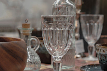 Textured transparent wine glass on served table. Front view.