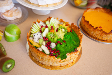Cake with fresh fruits apple kiwi dragon fruit pomegranate