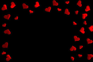The Concept Of Valentine's Day. Border of a scattering of red hearts on a black background. Free space for your text.