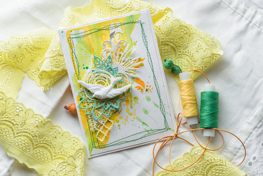Yellow and green scrapbooking greeting card with flowers, butterfly, bird. Spring concept. Greeting cards for wedding or other festive decorations . Tools for scrapbooking.