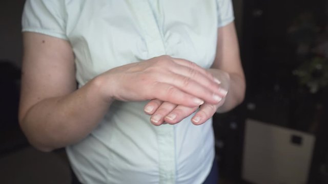 Close up of senior woman applying moisturizer hand cream at home