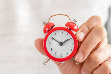 Red alarm clock in hand. Time management. Time take action. Deadline concept.