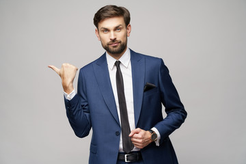 Portrait of a young businessman pointing on a copyspace with his finger