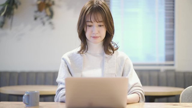 カフェでノートパソコンを操作している女性