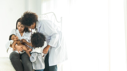 Smiling female doctor listen consult cute african boy make notes in patient card at medical checkup appointment, black dad and child son visit pediatrician talk in clinic, children healthcare concept