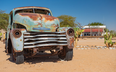 Autowracks stehen wie in einer Oldtimer Ausstellung an der Tankstelle / Rastplatz Solitaire am Rande der Wüste Namib, Khomas, Namibia