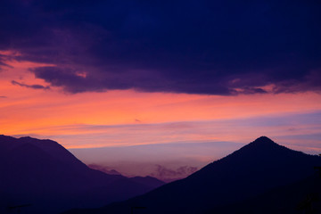 Fototapeta na wymiar Cielo rosso del tramonto sulle montagne