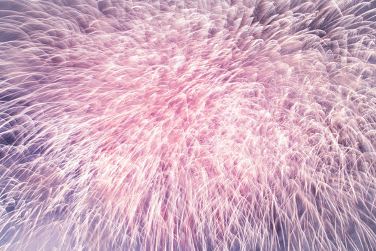 Rose quartz pink feathery lights glow on Ultra violet sky background. Abstract pastel pink and purple texture. New Years celebration fireworks closeup, Prague, Czech Republic.