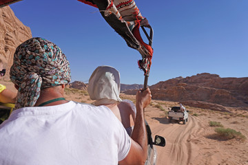 Jordan, The Wadi Rum Desert - tourist visiting the desert with 4x4 jeep car     taking pictures                  © andrea