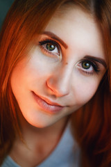 Fototapeta premium Close portrait of a beautiful green eyed young woman with ginger hair