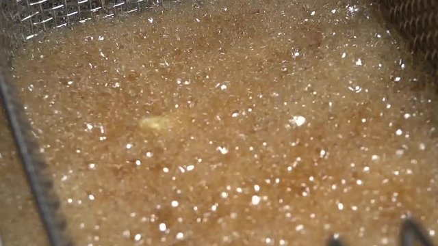 Pieces of potatoes floating in hot oil