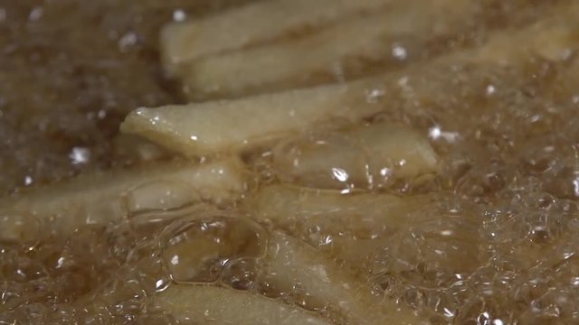 Pieces of potatoes floating in hot oil