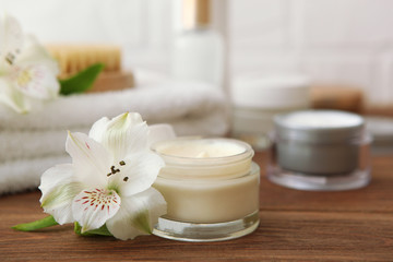 Fototapeta na wymiar skincare cream and flowers on the table. Cosmetics for skin care.