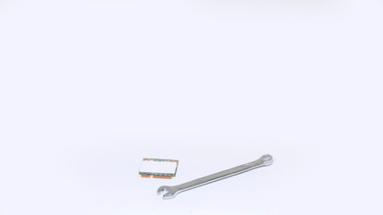 Small wrench and computer chip isolated on white background. Repairs concept.