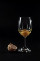.egg in a glass, onion on black background glued with adhesive tape