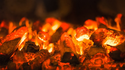 Abstract background of glowing orange red-hot wooden charcoal closeup at summer night. Campfire adventurers relax around fire place concept wallpaper