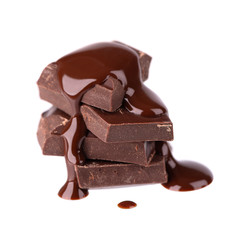 Chocolate pieces stack and chocolate syrup isolated on white background. Close up.