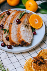Roasted turkey or chicken with orange slices in plate for Christmas dinner served and festive decoration on dark rustic background
