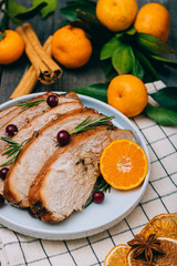 Roasted turkey or chicken with orange slices in plate for Christmas dinner served and festive decoration on dark rustic background