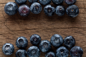 Freshly picked blueberries in wooden background. Juicy and fresh blueberries with green leaves on rustic table.Concept for healthy eating and nutrition