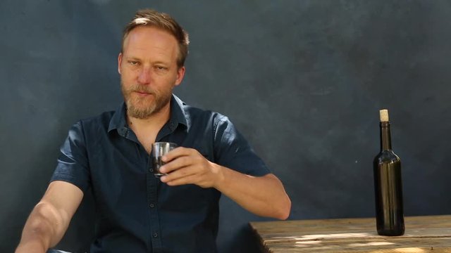 Hombre de mediana edad con aspecto de aleman bebiendo un vaso de vino 
