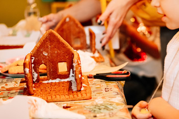 cooking gingerbread cookies, a house of cookies for Santa, kids are preparing to eat, decorating the house
