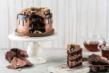 Delicious sponge cake with meringue and chocolate close-up. Sliced into pieces on a wooden catering stand.