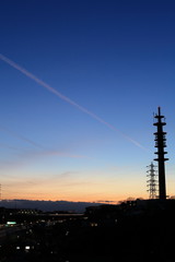 飛行機雲、電波塔と夕暮れ
