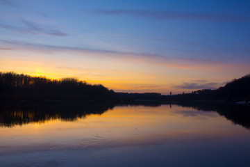 Fototapeta na wymiar Plain river in the fall after sunset.