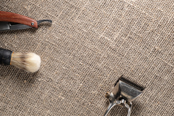 vintage barber tools dangerous razor hairdressing scissors old manual clipper comb shaving brush. on sackcloth background.