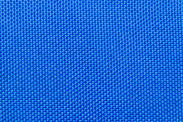Close-up of blue nylon fabric background texture. Sturdy woven fabric for sports equipment or backpacks. Macro photograph.