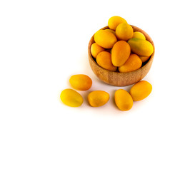 Ripe kumquat fruits in a small bowl. Isolated on white background. Copy space for text.