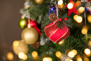Christmas toys balls on the Christmas tree red gold on the background of Christmas lights. Background for greeting card, calendar
