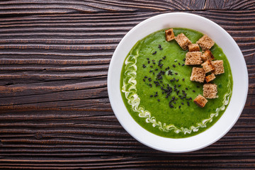 broccoli spinach cream soup on rustic wooden background