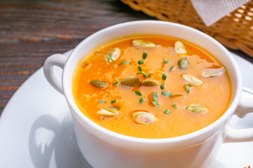 pumpkin cream soup on rustic wooden background