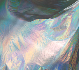 iridescent holographic fabric. sparkling background with waves and colored tints
