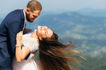 Close-up of newlyweds who have fun. The groom embraces her bride