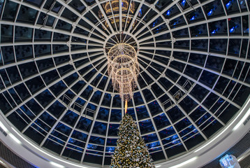 Glass roof with a huge chandelier in a Christmas shopping center.