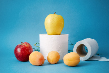 fruits and toilet paper on a blue background. Natural remedy for constipation. Healthy digestion...