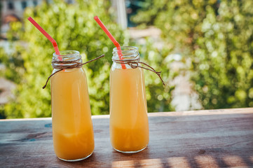 Bottle of Freshly squeezed orange juice on a wooden table.