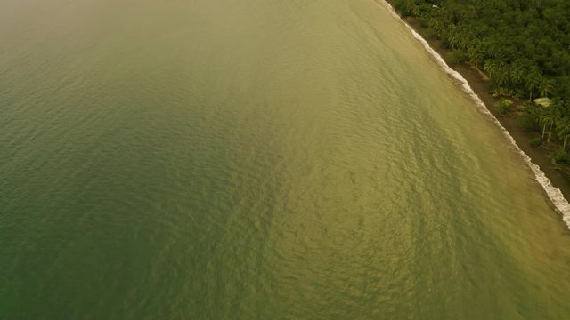 Aerial tilting up to the beautiful untouched Pacific Coast and jungle in Nuqui, Colombia.