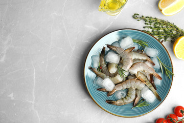 Flat lay composition with fresh raw shrimps on light grey marble table. Space for text