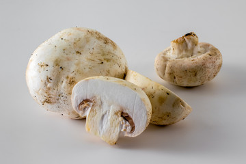 Whole and halved cut mushrooms isolated, close-up. White agaricus bisporus mushrooms.