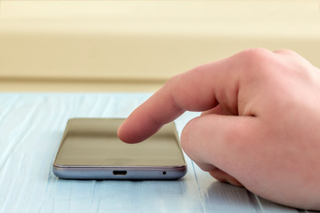man presses his finger on the screen of the phone, close-up